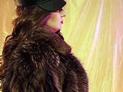 Wanita dewasa mendominasi dengan mantel bulu dan sarung tangan kulit dalam video buatan sendiri