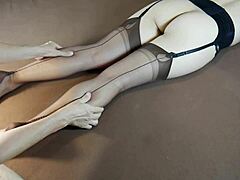 Una donna matura vestita di nylon fa un massaggio ai piedi in calze